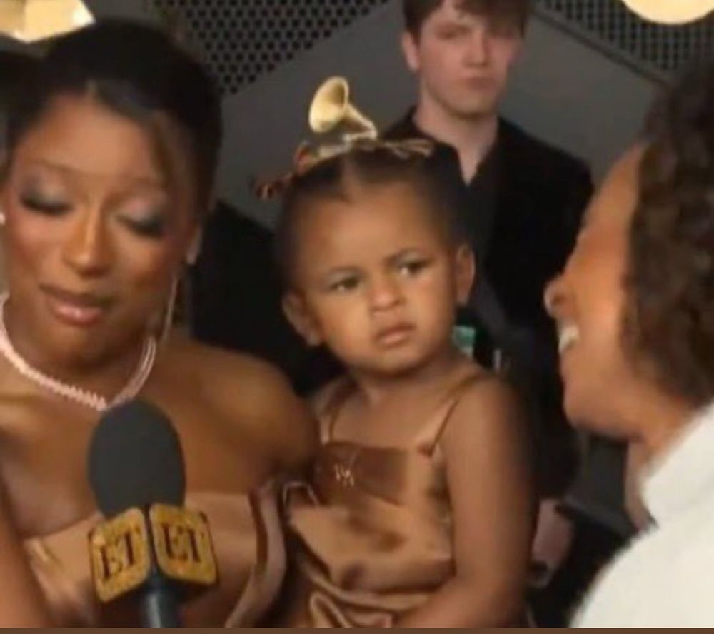 Victoria Monet holds her baby, who stares at the interviewer with a face of scrutiny. 