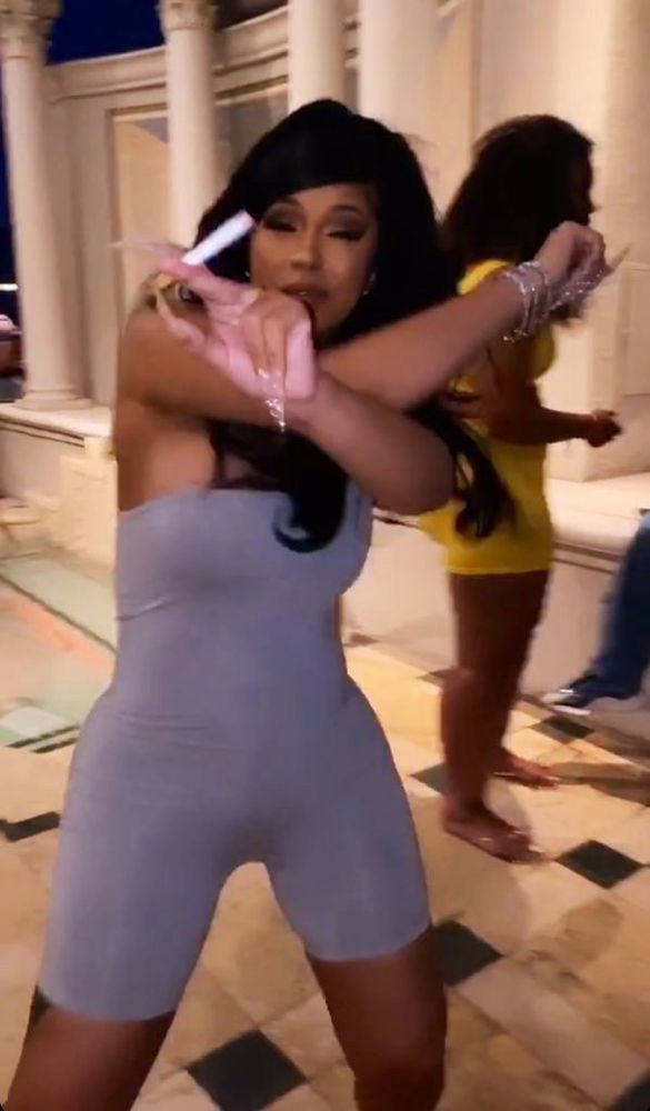 Cardi B dances at a camera with a cigarette in her hand 