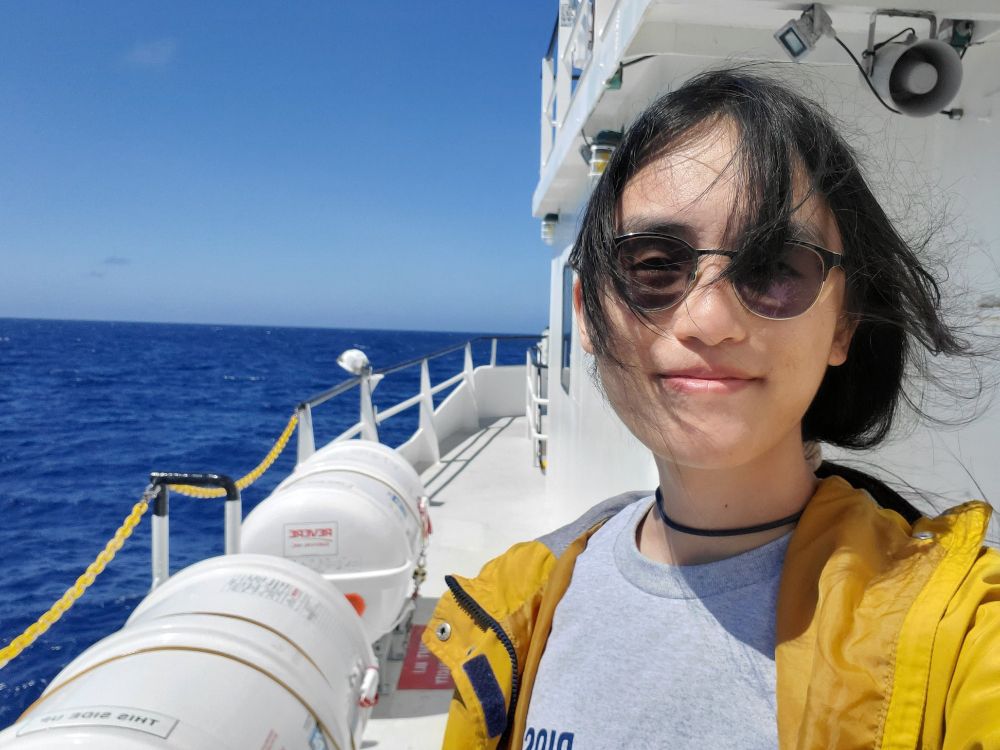 Mica on the deck of the R/V Atlantic Explorer with a blue ocean and sky as the background. Photo provided by Mica Yang. 