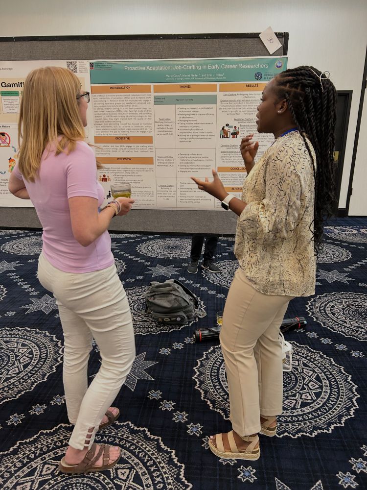 Marie Delcy presents her research on "job crafting" to another person as they both stand in front of her poster at the 2025 Society for the Advancement of Biology Education Research (SABER) Meeting. Photo provided by Erin Dolan. 