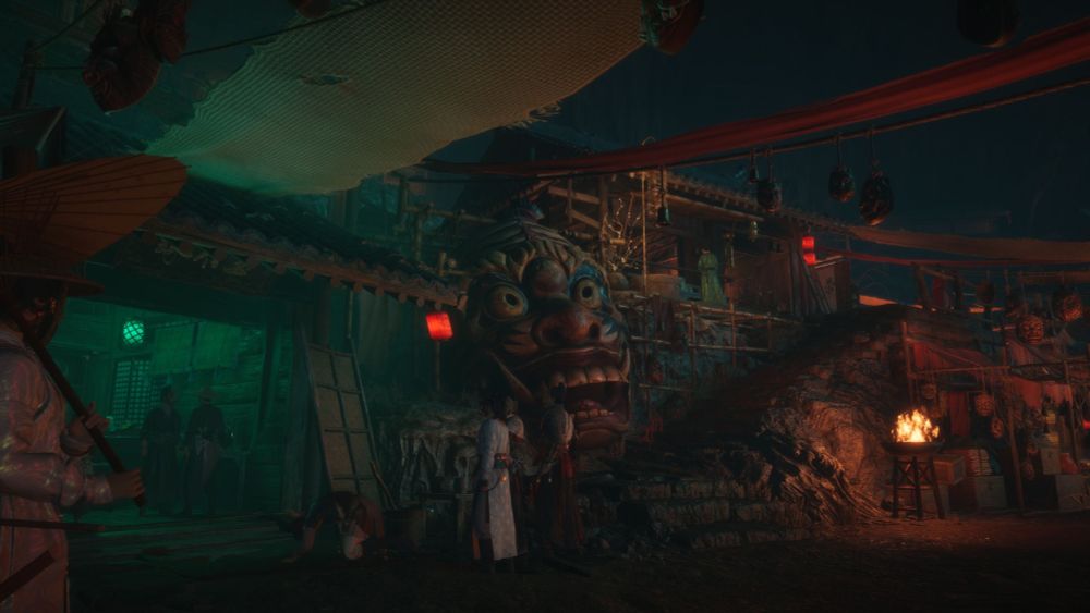 A giant mask sits along the side of road, carved from the rock and watching all the shoppers go by in silence.