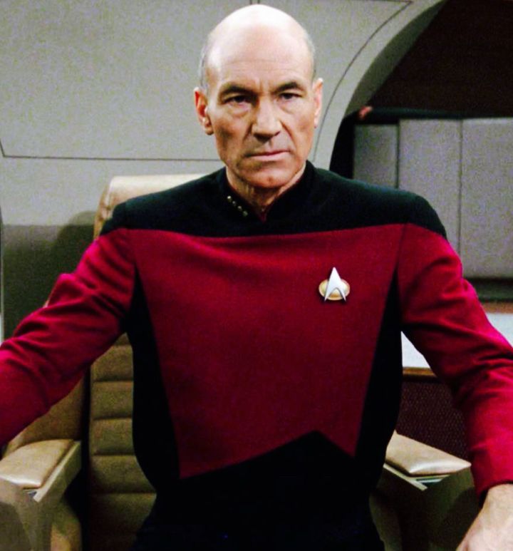 Sir Patrick Stewart wearing his reddish Star Trek uniform. 