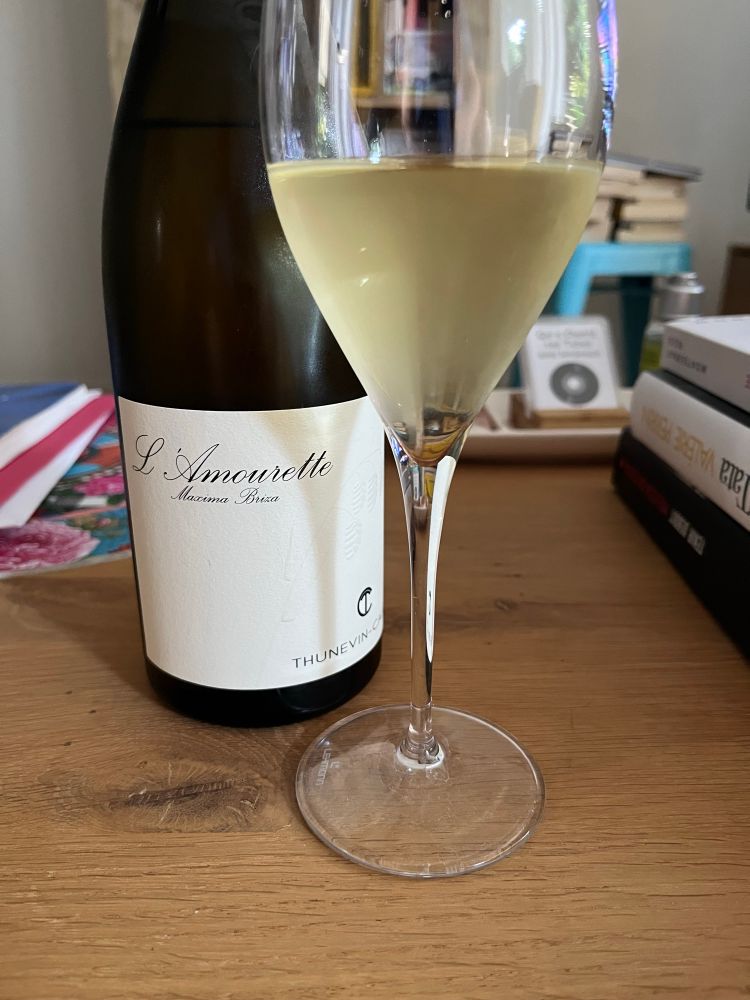 Un verre de vin blanc et une bouteille L’Amourette.