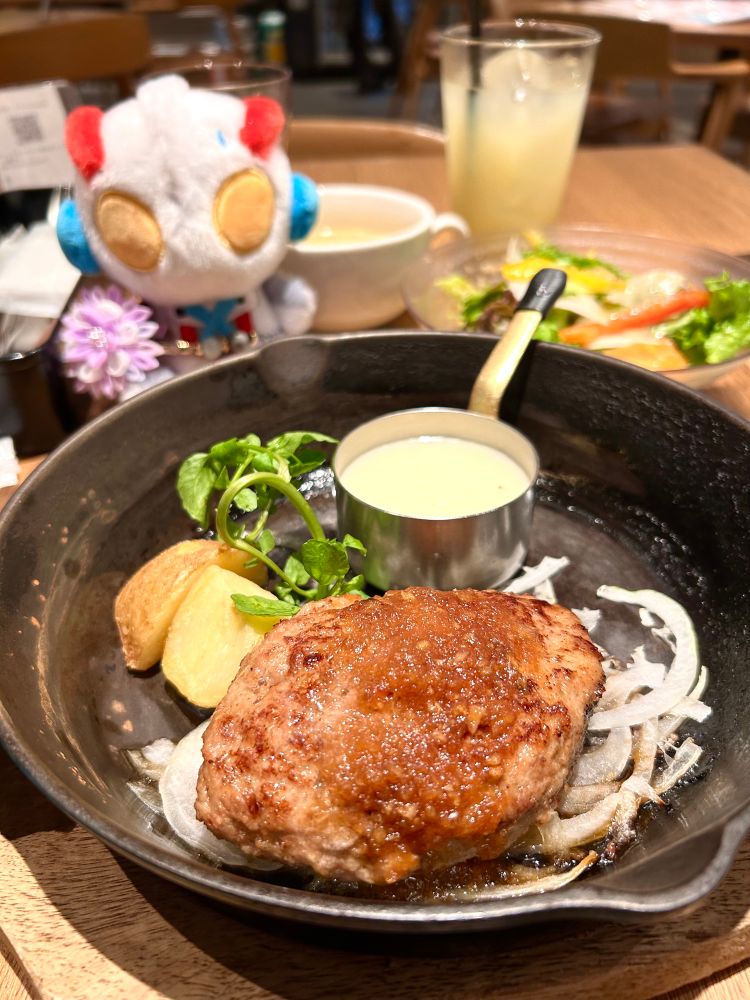 鉄製の小さなフライパンに乗ったハンバーグと、ふわぬいエックス。
ハンバーグは、醤油ベースの大根おろしソースがかかり、チーズソースも添えられている。