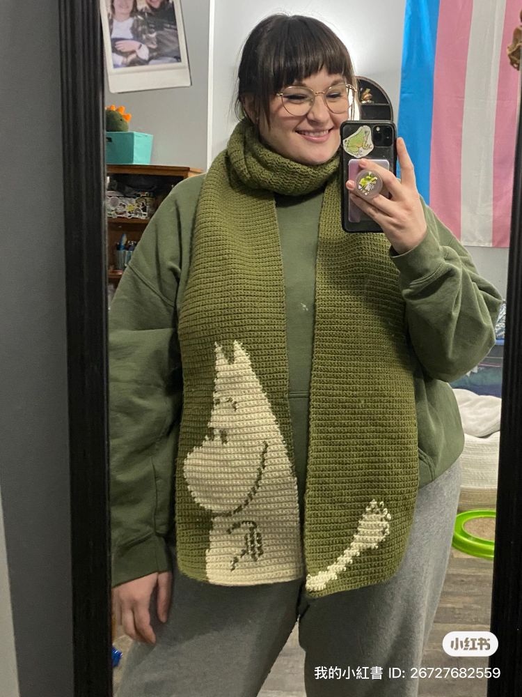 A green crochet scarf featuring the character, Moomin