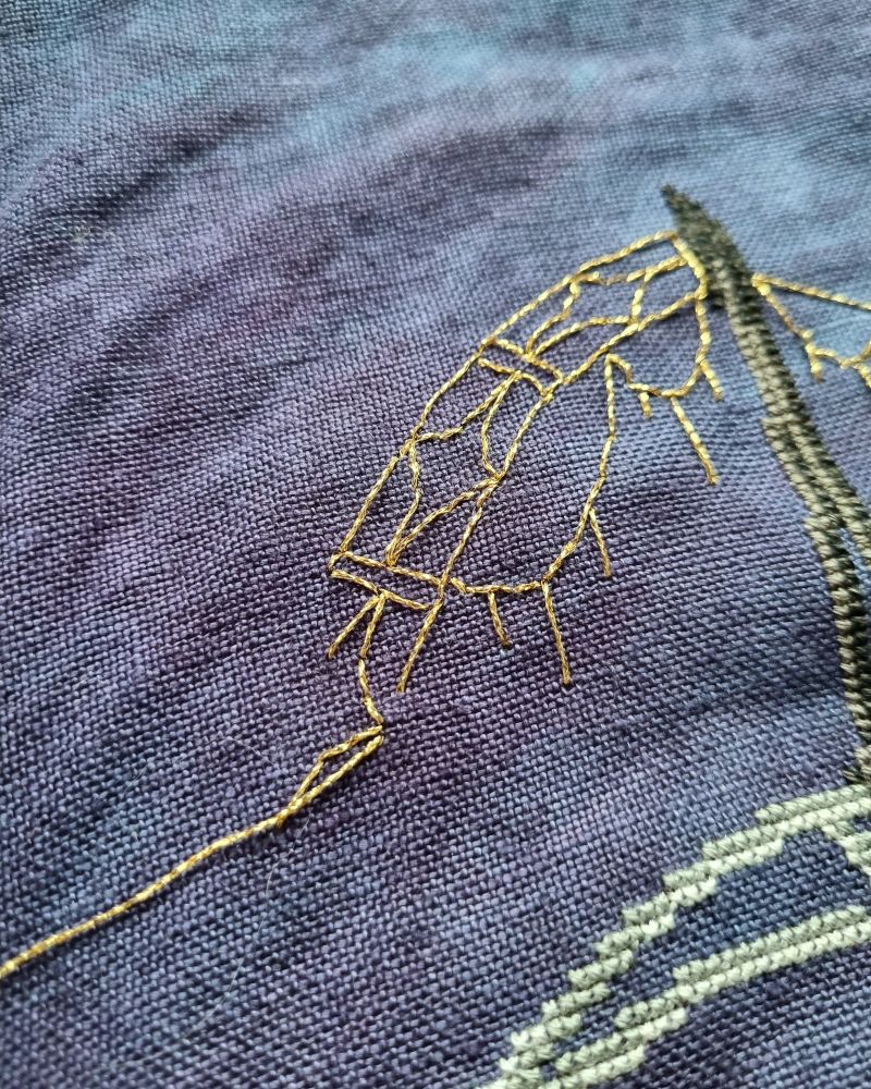 Close up of an ornate gold back stitch border