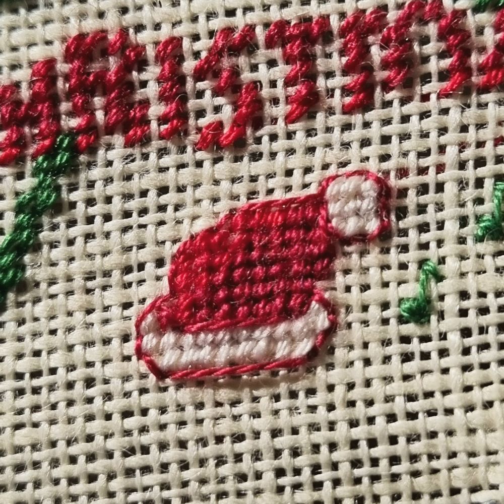 Close up of a cross stitched santa hat