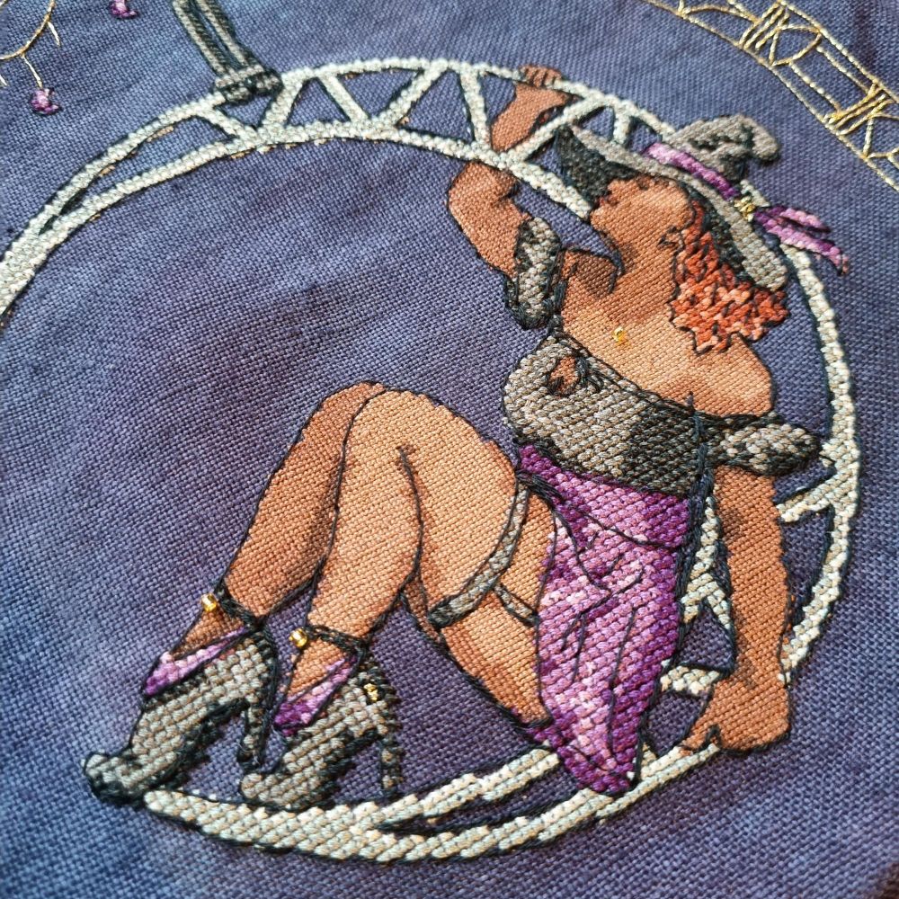 Cross stitch of a witch in a moon lyra, with backstitch