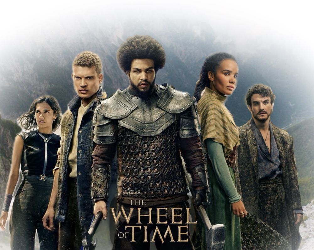 A poster for The wheel of time season three that was made by me (Kevin) using the character models from the new posters released today. The background is an arial view of their hometown, the two rivers, surrounded by the mountains of mist. Standing left to right are Egwene al’Vere, Rand al’Thor, Perrin Aybara, Nynaeve al’Meara and Mat Cauthon, often referred to as The Emond’s Field Five, or EF5. Egwene is in a black sleeveless shirt with an x on the belt and black form fitting pants, Rand is in a threadbare jacket with his sleeves rolled up looking angry, Perrin’s eyes are golden and he is in a leather armor chest piece with metal shoulder armor, holding both a hammer in his left hand and an axe in his right, Nynaeve is in a green dress with a lighter green shawl with her accept ring visible on her hand, and Mat is in a fine silk coat over a wrinkled undershirt with a Fox head medallion poking out the unbuttoned top of the shirt. “The wheel of Time” is written between the hammer & axe in gold font. 