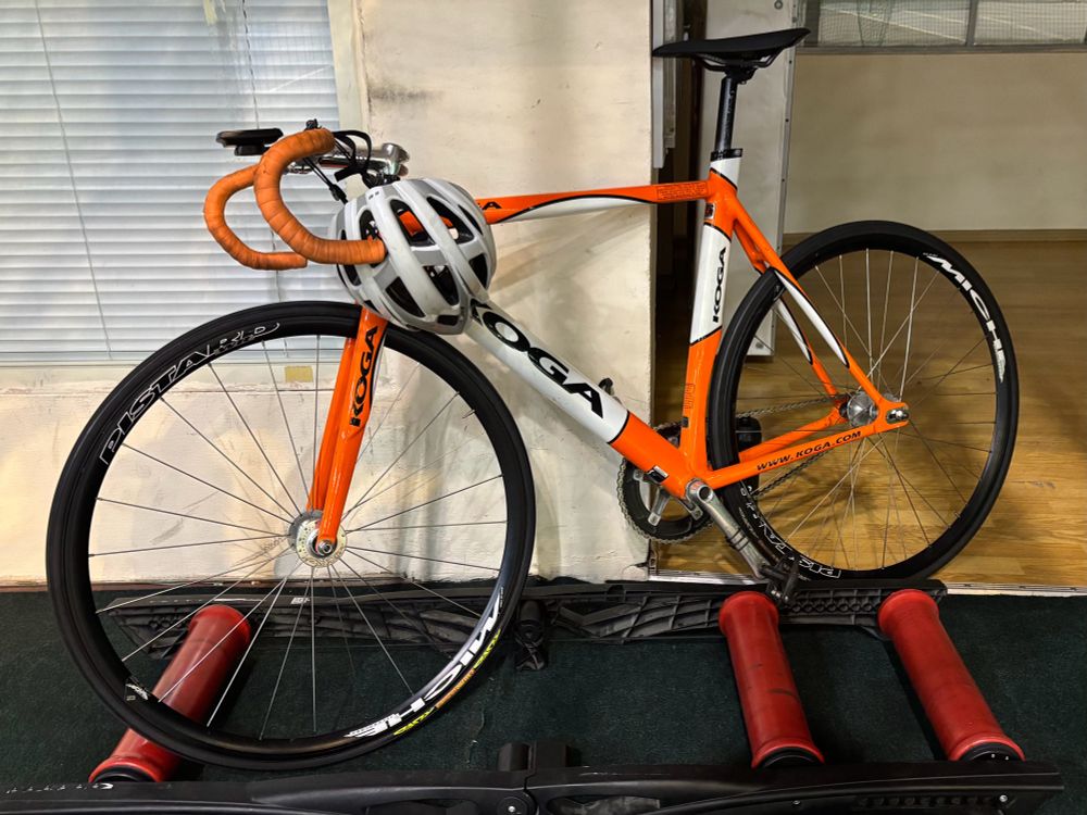 Orange track bike on a roller trainer
