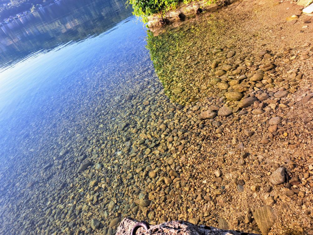 Seichter See Einstieg mit Kieseln bedeckt.