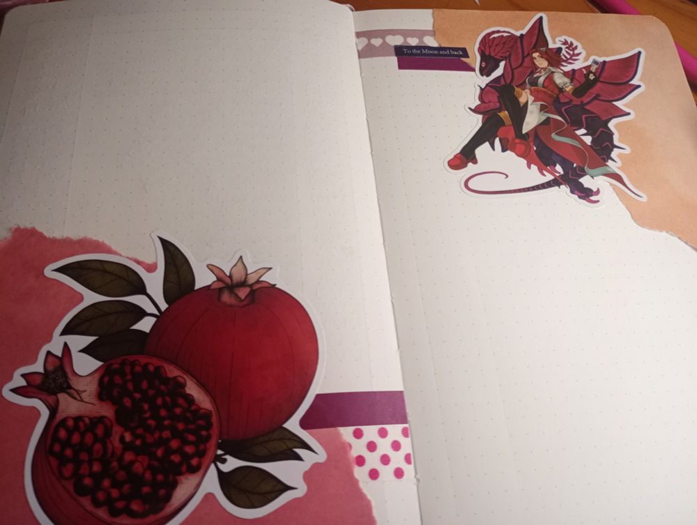 a photo of a half-finished bullet journal layout. it has red and orange origami paper on the bottom left and top right corners respectively. the left corner has a pomegranate sticker, some purple washi tape, and some spotty red washi tape. the right corner has a sticker of aki izayoi from yugioh 5ds, the same purple washi tape, a brown-purple washi tape with white hearts on it, and a very small piece of dark blue washi tape that reads, "to the moon and back" on it.