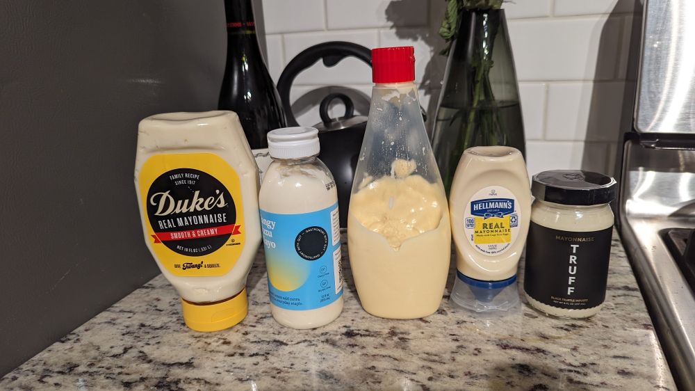 A selection of mayonnaise from Jaina's fridge, displayed on the counter.
From left to right: Dukes Mayonnaise, Acid League Tangy Yuzu Mayo, Kewpie Mayo, Hellman's Mayonnaise, Truff Black Truffle Mayonnaise