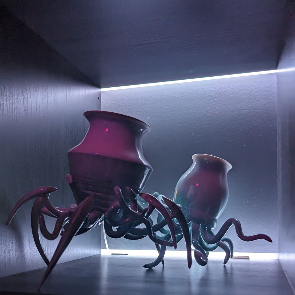 Two pots skittering around in a room backlit by a lightbar