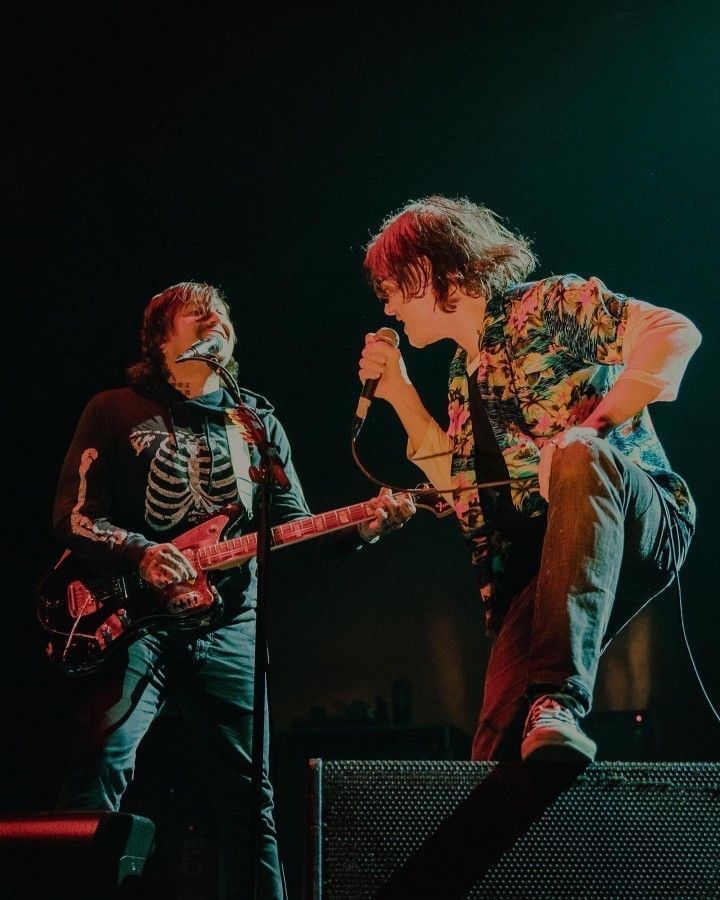 Onstage with Frank in 2022, he’s looking at Frank and Frank is smiling
Gerard is wearing a Hawaiian shirt over a long sleeve tshirt and Frank is wearing a skeleton hoodie