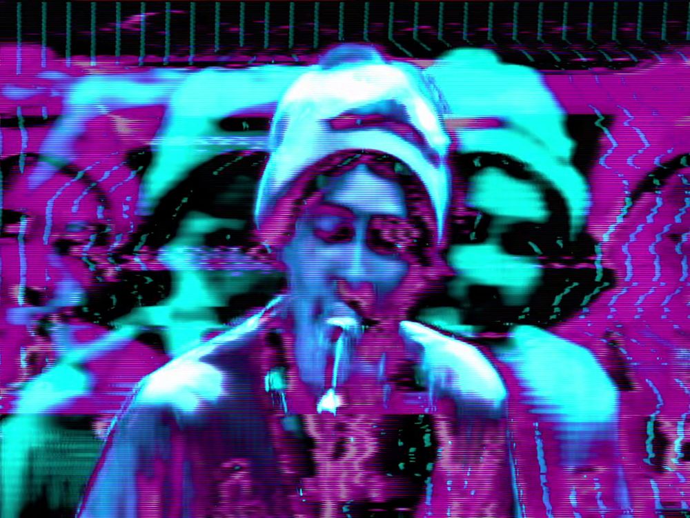 The singer from animal collective, glowing a glitchy blue. Echoes of his image flank him in the background