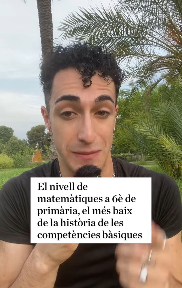 Captura de pantalla del vídeo de IG que adjunto. Se ve a un chico de unos 25-30 años, pelo corto y rizado, moreno, con pendientes y camiseta negra sobre un fondo de plantas y palmeras. Le acompaña un texto en catalán: "El nivell de matemàtiques a 6è de primària, el més baix de la histoʻria de les competències básiques".