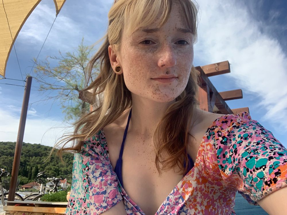 A selfie of me sitting outside in a multicoloured dress 