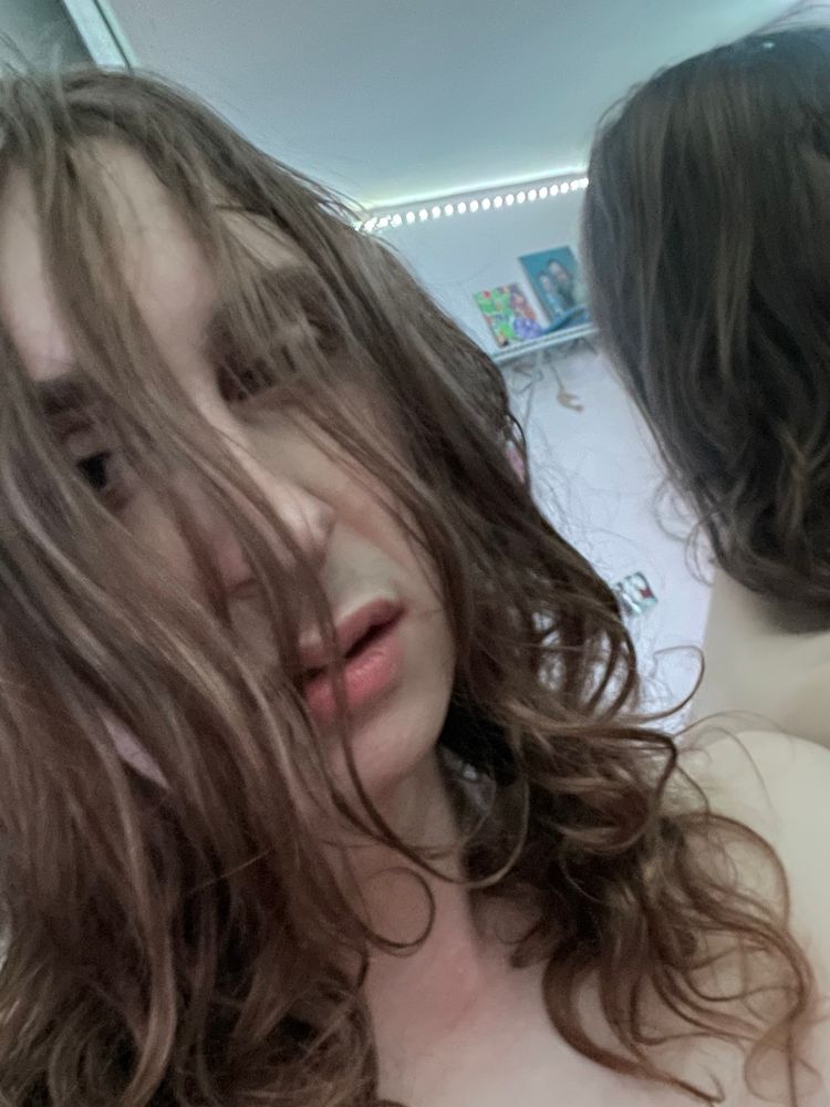selfie of Luna standing with her back facing a mirror. She has a dazed look in her eyes, mouth slightly agape, and her hair is a mess, bangs falling across her face. She’s naked but only her face and left shoulder is showing.