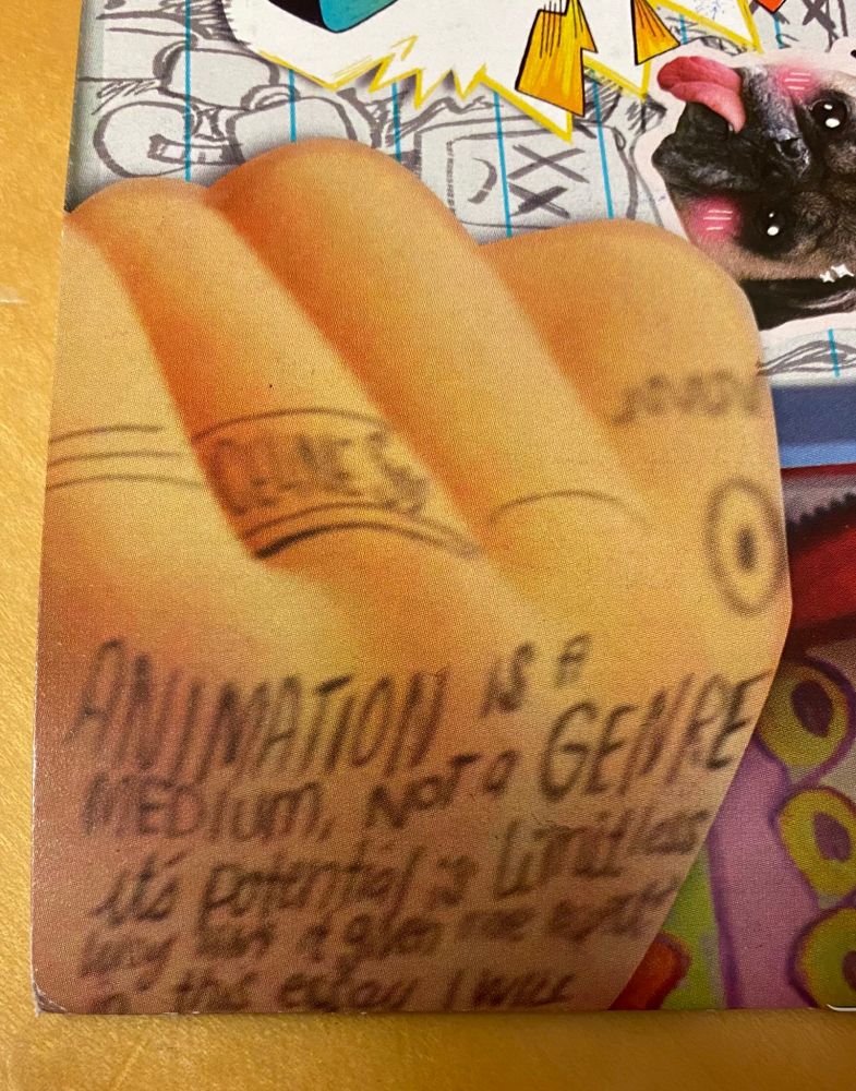 A corner of the movie poster for Mitchells vs the Machines.  On the back of a hand is written "Animation is a medium, not a genre" in captials, followed by "it's potential is limitless *unclear* in this essay I will".