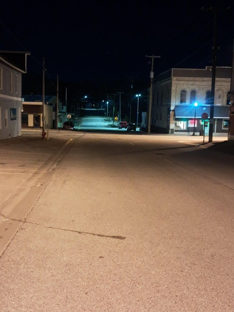 A deserted night-time crossroads in a small town in America.