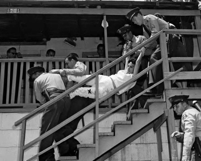 A woman being carried, against her will, down the steps of a house in Chavez Ravine on May 8th, 1959.