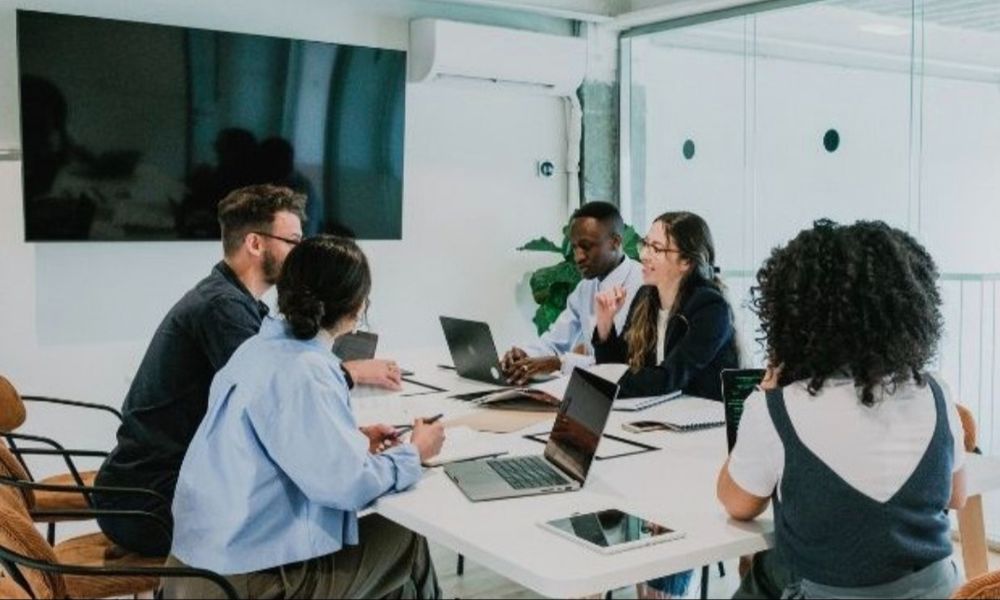 A photo of team of people working together at a table 