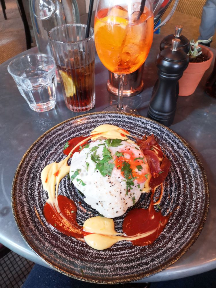 A photo of a bubble and squeak meal with an aperol spritz from Old Compton Brasserie.