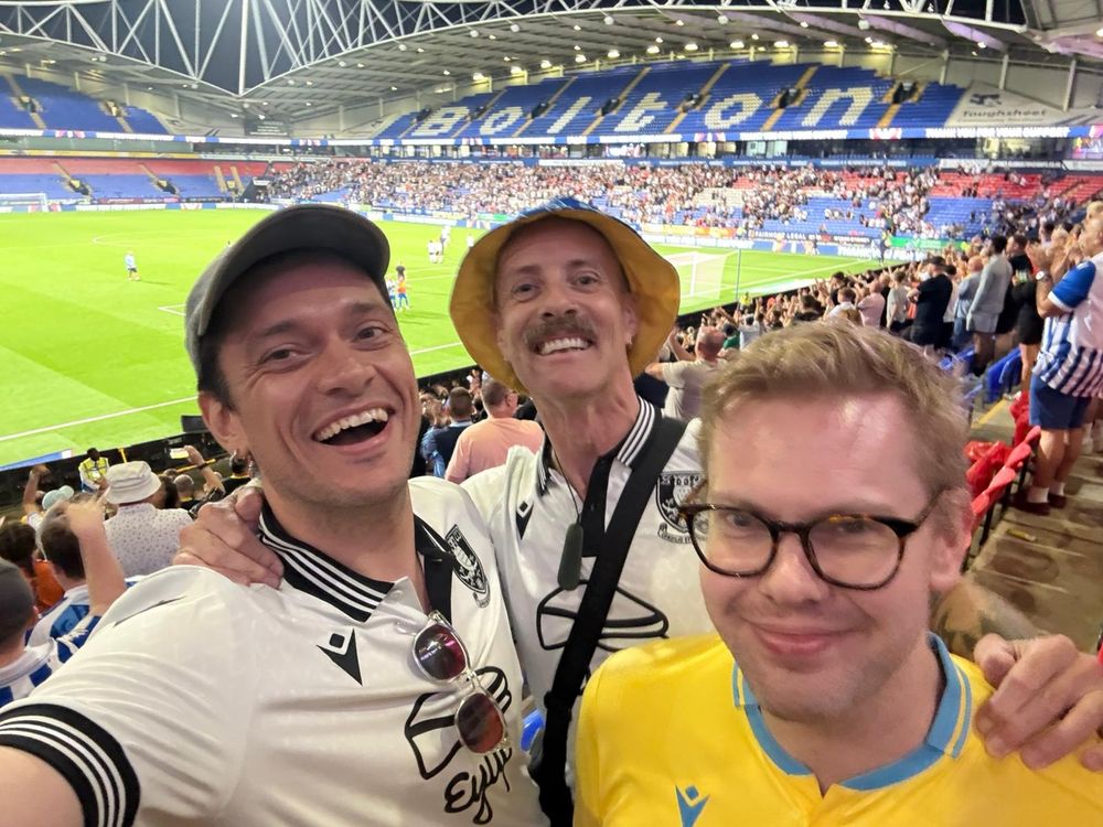 A photo of me, with two Rainbow Owls members, smiling in the away stand of Bolton Wanderers vs. Sheffield Wednesday.
