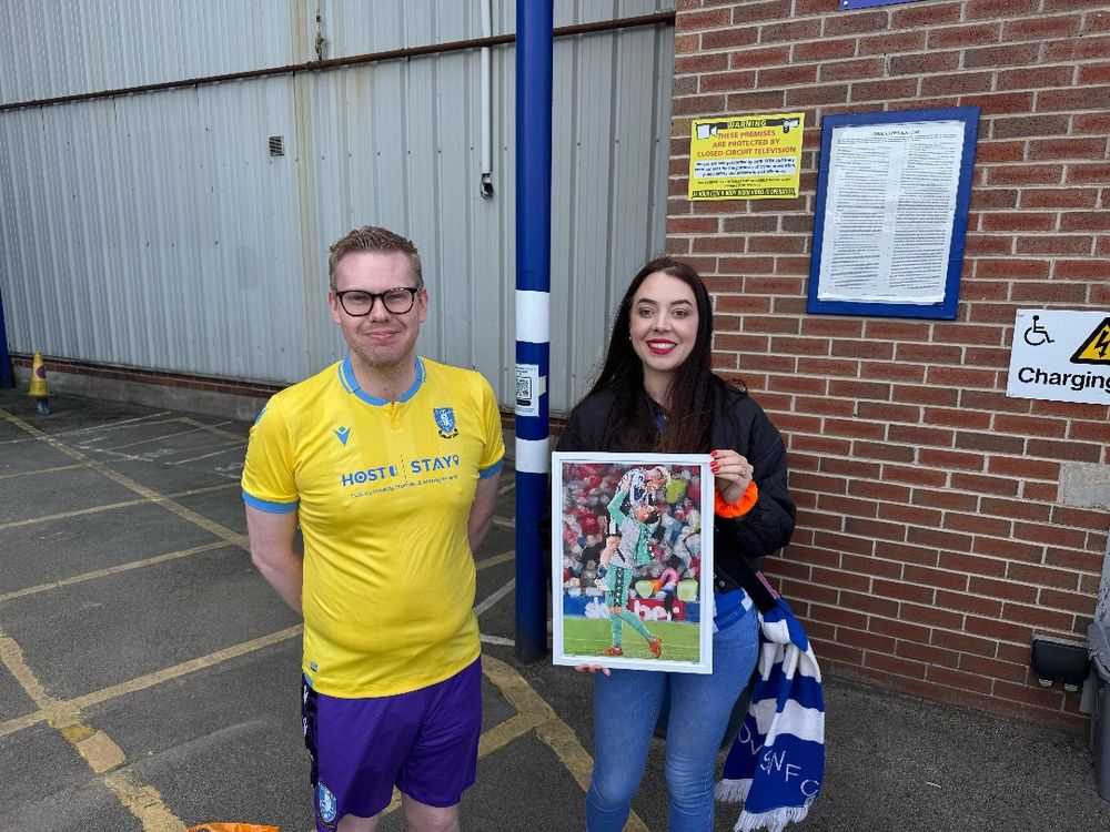 A photo of Hollie from The Wednesday Week podcast holding a framed Barry Bannan and David Stockdale print outside the club's Megastore with me.