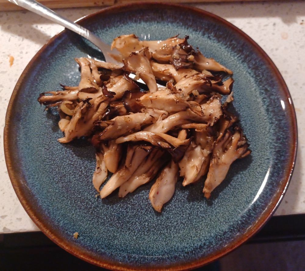 Cooked Maitake mushrooms on a blue plate with a silver fork.
Baking 350F for 10min. 
Sautee some minced garlic in butter, toss in the mushrooms, salt+pepper+thyme. Eyeballed it, probably about 5~7 minutes saute.