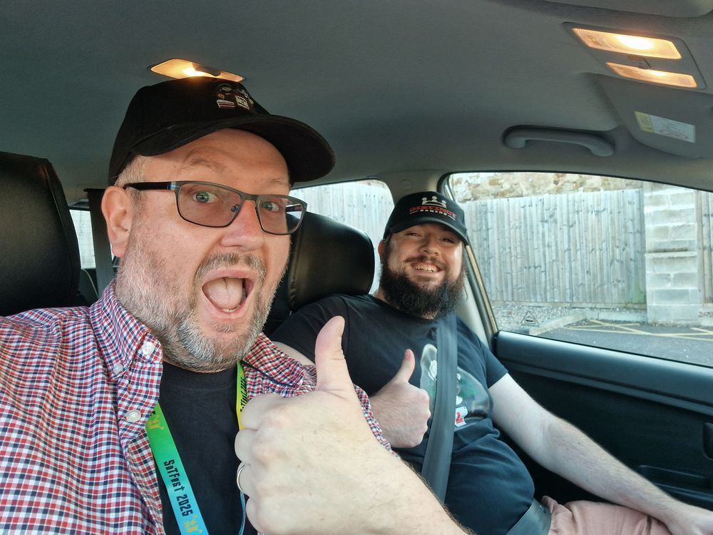 DG and his friend Adam, sat in a car. DG has his thumb up and they are both happy to be going to SoTFest
