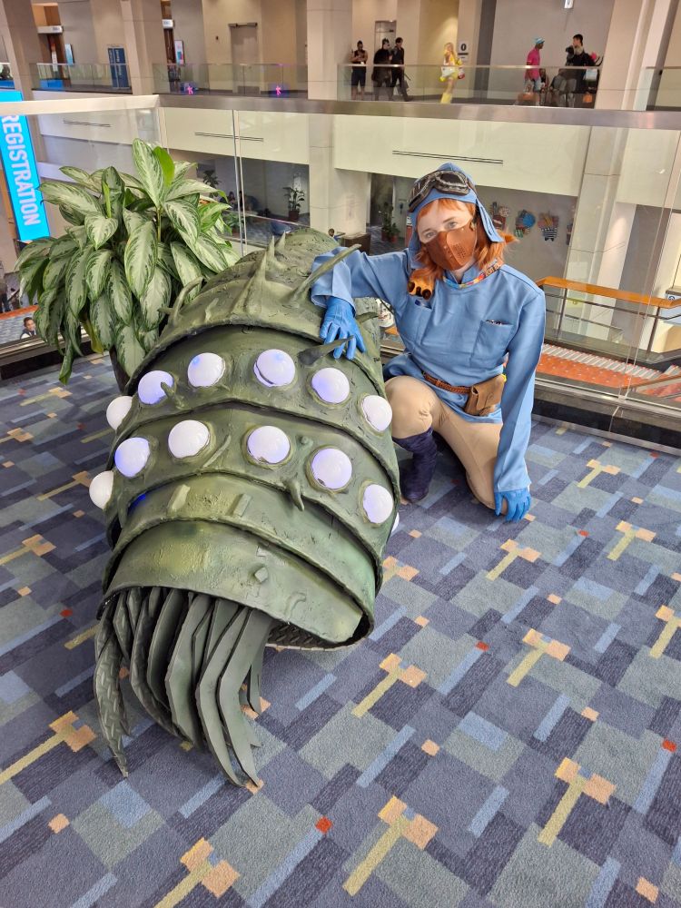 A Nausicaa cosplayer with a to-scale Baby Ohmu prop