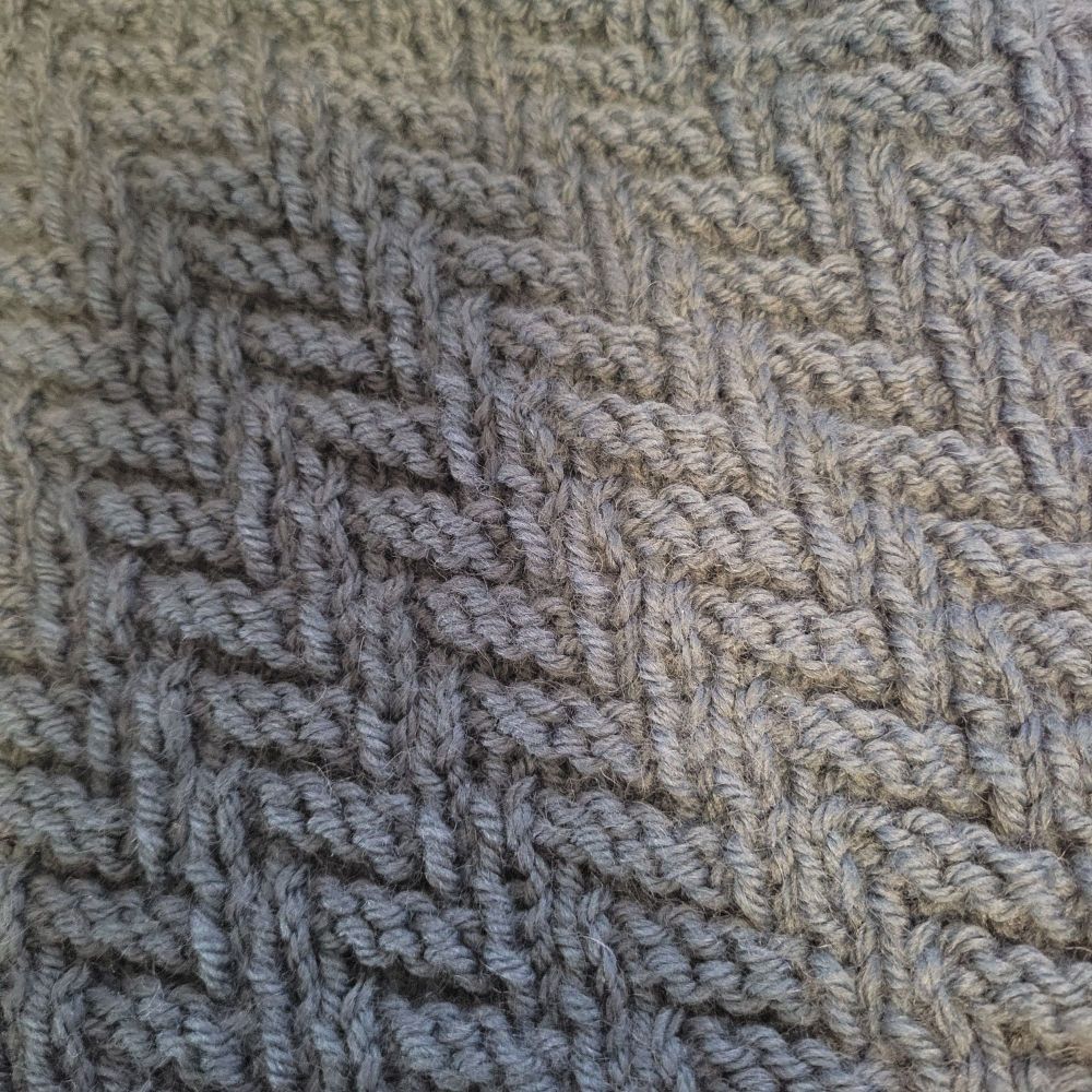 Grey blue knitting in a repeating Z pattern