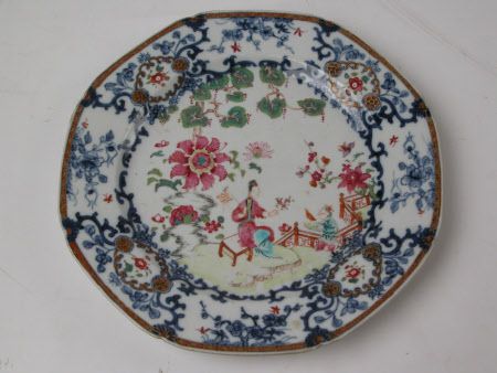 'Plate, porcelain, of octagonal shape, painted with blue floral motifs edging with gold rim, and central image of a figure in a red kimono sitting in a garden, Jingdezhen, China, decorated in Guangzhou (Canton), ca. 1750.' National Trust, Osterley NT 771529.