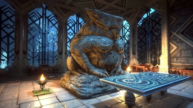 Screenshot from the video game Dragon Age: The Veilguard 

The image shows a dimly lit, ornate room featuring a large stone statue and an elaborately detailed table. The stone statue depicts a creature with a toad-like form and an exaggerated, stylized animal head, sitting on a wide base. Its surface is rough and textured, reflecting a bluish-gray colour due to the lighting. The room is decorated with an intricate geometric pattern on the walls and composed of tall columns that frame metal lattice windows, allowing some light to filter through. The floor is tiled with large, rectangular stones. On the left, a small, lit brazier emits a warm glow, contrasting with the cooler tones. In the  foreground, the table has an elevated design with a geometric pattern on its top surface.