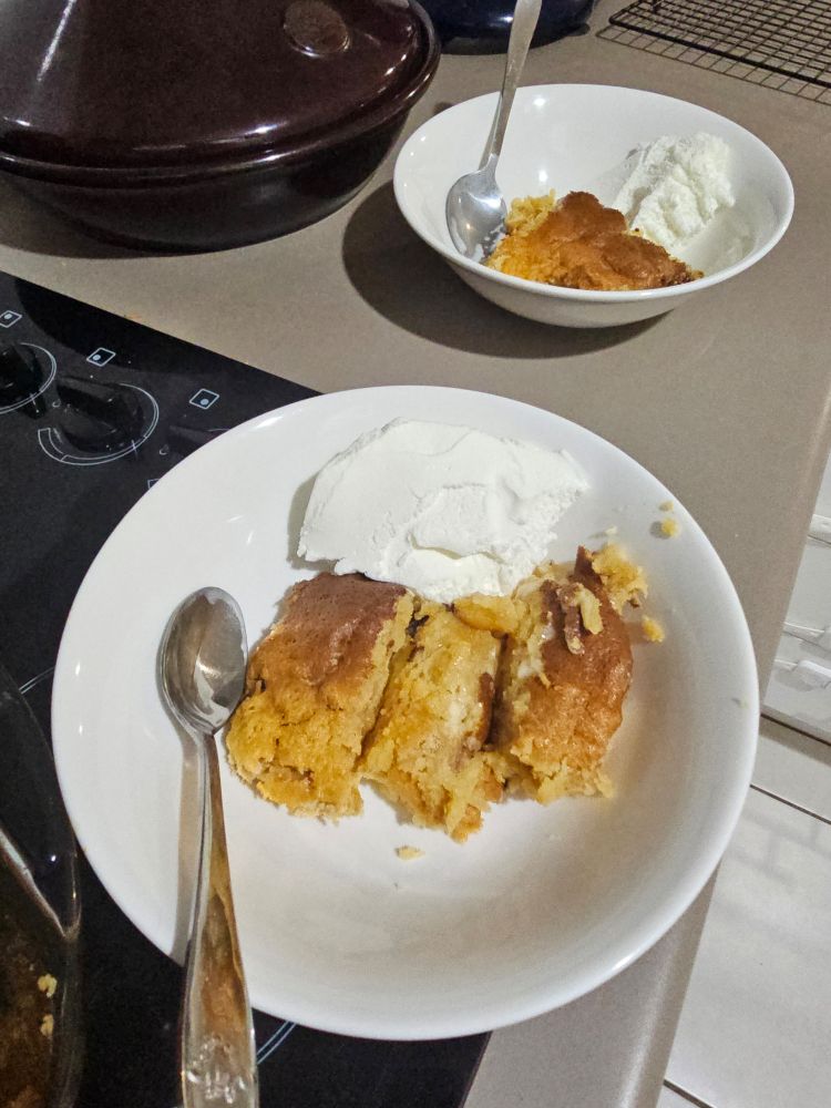 Two white bowls containing a bread pudding-like dessert with ice-cream.