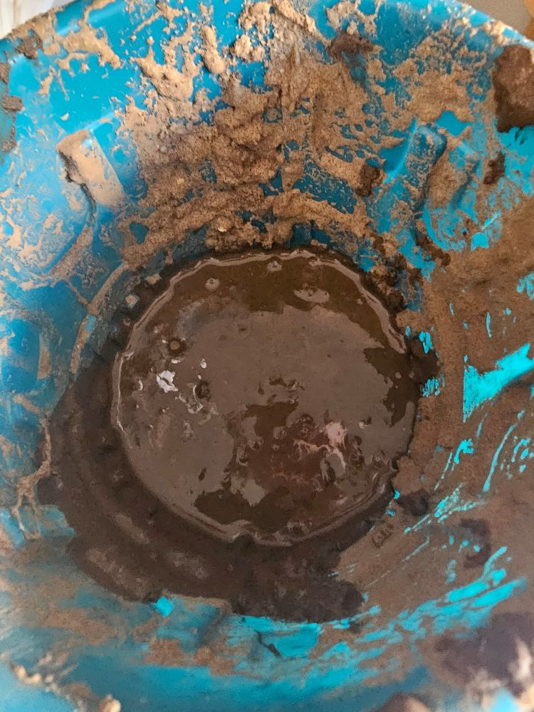 A blue bucket full of mud.