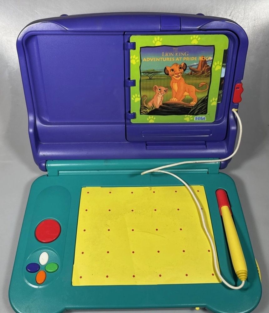 a photo of the early childhood/educational video game console the Sega Pico with a “Lion King Adventure at Pride Rock” cartridge inserted 