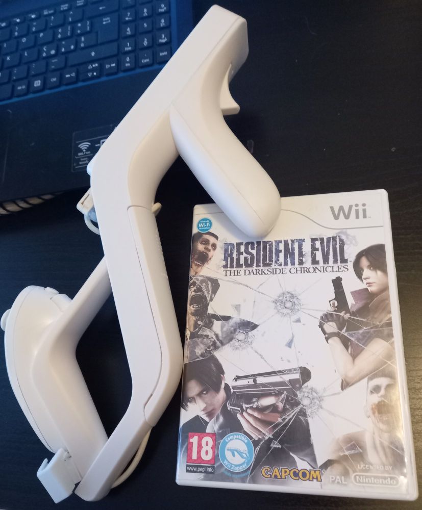 Photo of a wii remote + nunchuk combo fitted in a cheap wii zapper reproduction frame and a game case for "Resident Evil: The Darkside Chronicles"