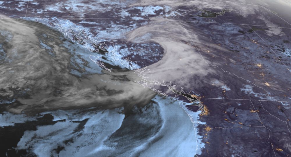 A satellite image of British Columbia showing a comma shaped cloud pattern over the province indicating a low pressure system and cold front.