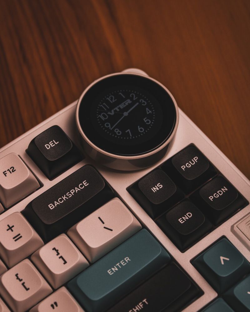 The multimedia knob of a Feker VTER K75 mechanical keyboard showing an analog clock. 