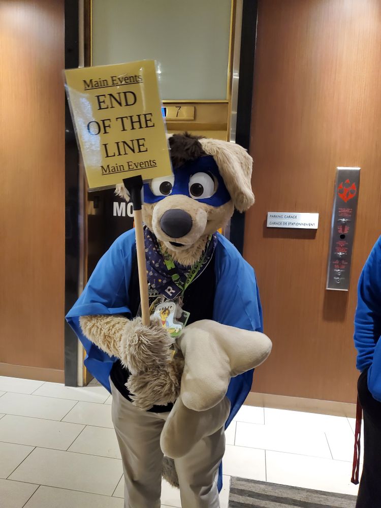 A picture of RK9er in his fursuit, holding a sign that says "END OF THE LINE"
