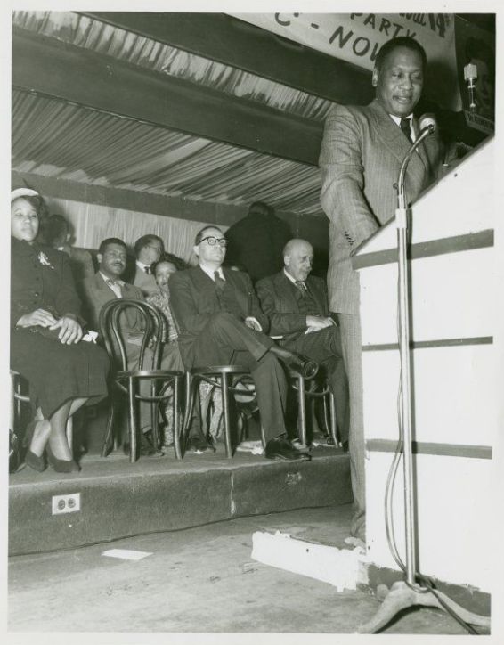 Paul Robeson speaking at a Labor Party Rally at Madison Square Garden, October 24, 1950. Du Bois, who was running for US Senate on the Labor Party ticket, is seated in the background.