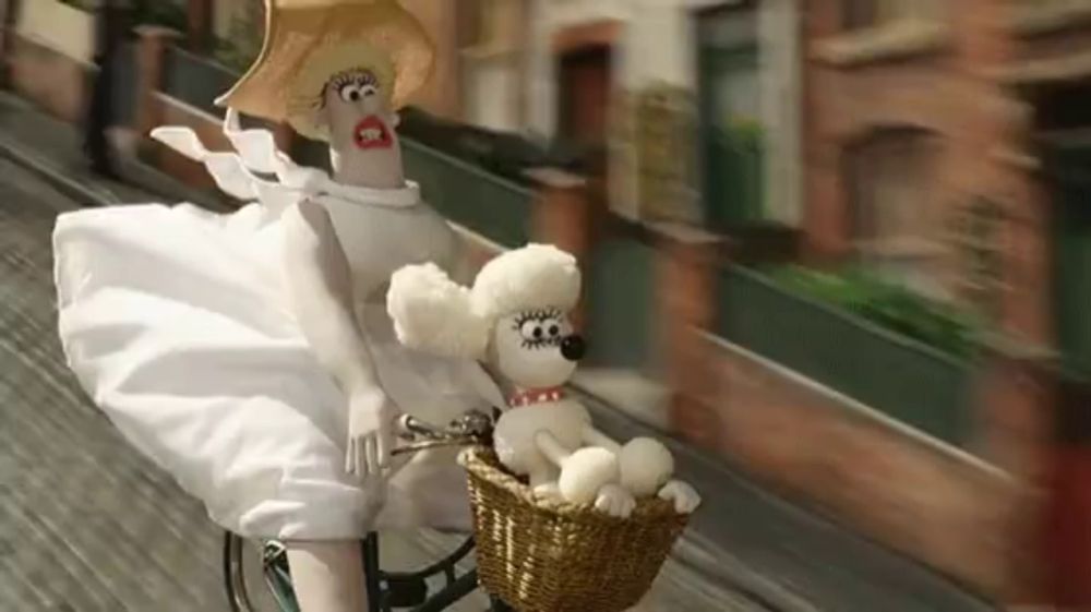 a woman in a white dress is riding a bike with a stuffed dog in a basket .