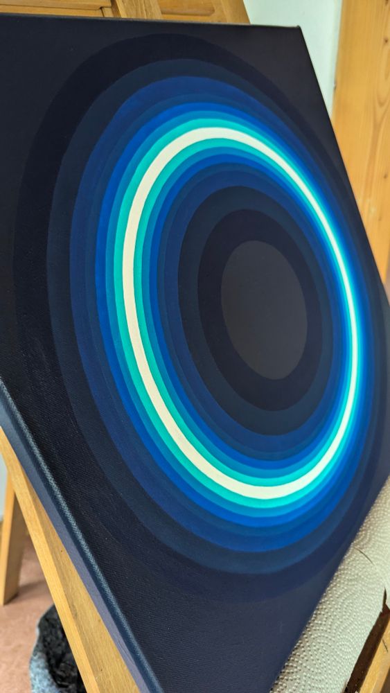 Leinwand auf einer Staffelei seitlich fotografiert. Das Gemälde besteht aus konzentrischen Kreisen in Blautönen 