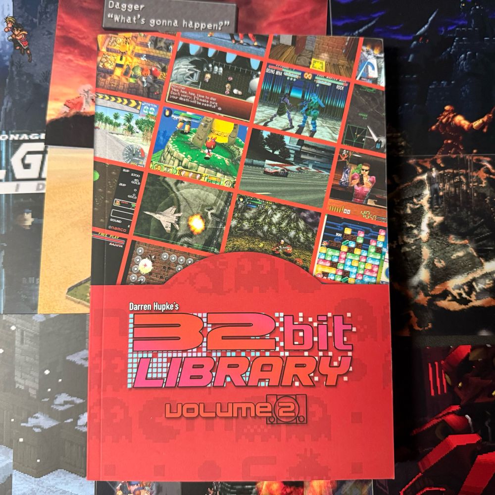 A red paperback book with the title “32 Bit Library Volume 2” featuring a number of screenshots from various video games on the cover. Inside is written retrospectives for every game covered and bonus material from industry friends. 