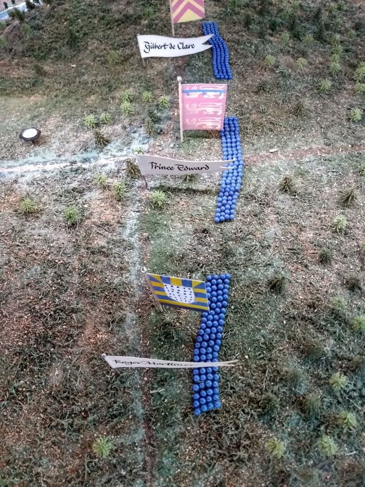 Image shows a close up of a plan of the Battle of Evesham. Prince Edwards forces are arranged in blocks and are represented by blue pins with flags showing the Barons that lead each unit.