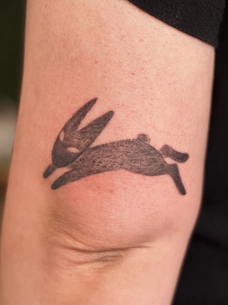 A tattoo of a charcoal style drawing of a rabbit 