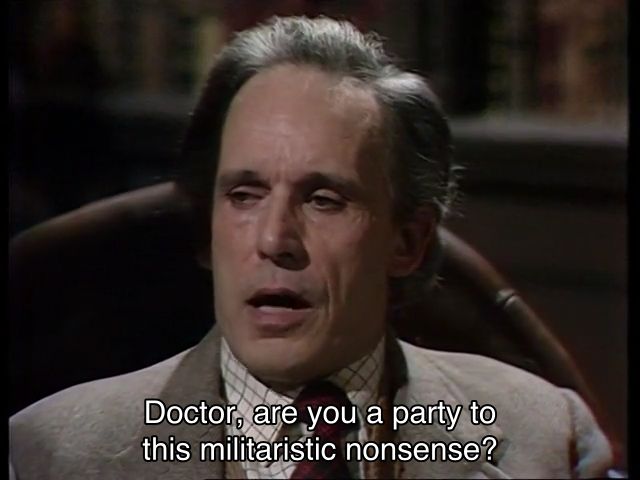 Tom Baker episode. (Aren’t they all?) A middle aged man in a nice grey suit is sitting in a big lovely castle, in a truly excellent looking chair. He looks unimpressed by the conversation he’s a part of. He says, “Doctor, are you a party to this militaristic nonsense?” The Doctor is putting his hat on a knight armor statue, and says, “I’m not a party to any kind of nonsense, your Grace.” [citation needed]